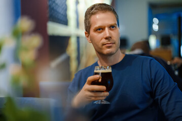 Man drinks beer at a bar.