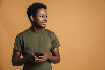 Young black man wearing t-shirt using mobile phone