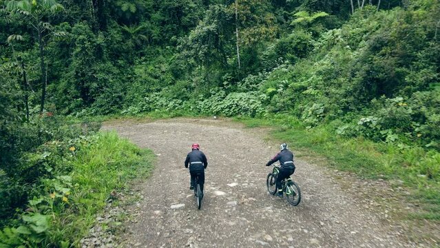 Drone follows two mountain bikers riding on Road of death, Yungas Road, Bolivia