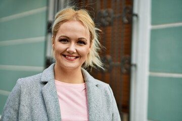 Fototapeta premium Young blonde businesswoman smiling happy standing at the city.