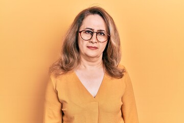 Middle age caucasian woman wearing casual clothes and glasses skeptic and nervous, frowning upset...