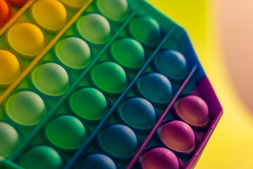 Close up shot of octagon pop it toy on colorful background. Indoors