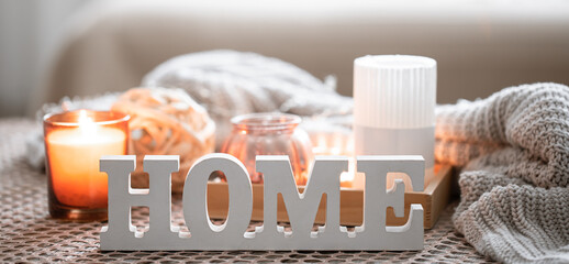 Fototapeta na wymiar Close up decorative word home on blurred background with candles.