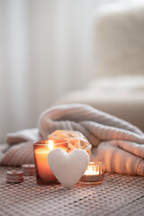 Cozy Valentine's Day background with a candle and a decorative heart.