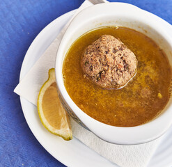  Bowl of soup with meatball on paper surface