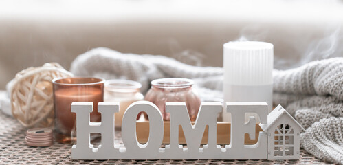 Close up decorative word home on blurred background with candles.