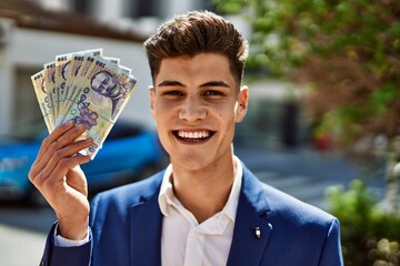 Young man wearing suit holding romania lei banknotes at park