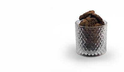 Round cookies with chocolate chips in a glass relief vase .Isolated on a white background.