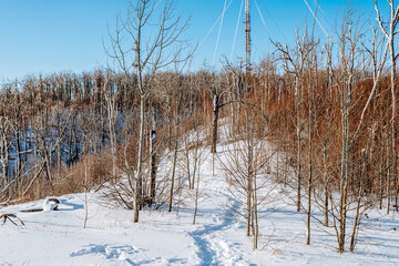 A TV tower on a high mountain covered with snow on a blue sky background