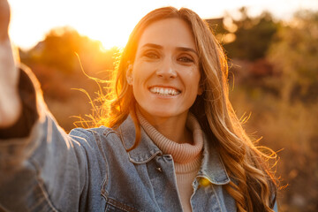 White ginger woman smiling while taking selfie photo