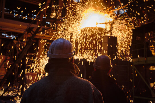 Metallurgists during the process of pouring steel from a ladle.
Ingot casting, metal sparks. Ladle-furnace. Iron smelting, Steel production. Electric steel furnace. Metallurgy. Industry steel producti