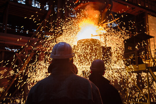 Metallurgists during the process of pouring steel from a ladle.
Ingot casting, metal sparks. Ladle-furnace. Iron smelting, Steel production. Electric steel furnace. Metallurgy. Industry steel producti