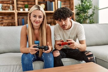 Fototapeta na wymiar Young couple smiling happy playing video game at home.