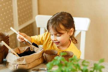 Girl transplanting plants at home into pots