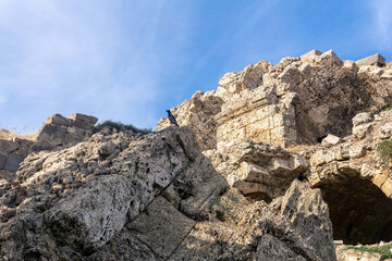 Fototapeta premium crow sits on a stone of ancient ruins against the sky