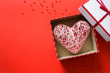 valentine's day. open gift box with big heart on red background with copy space. concept of giving...