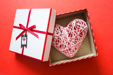valentine's day. open gift box with big heart on red background. concept of giving love
