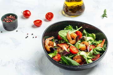 Seafood salad with smoked shrimps, cherry tomatoes, cucumber and mixed leaves. Healthy eating concept. Detox diet. Vegetarian lunch. Weight loss, top view