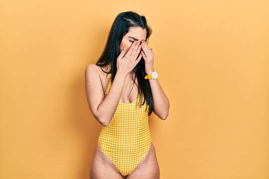 Young hispanic girl wearing swimsuit rubbing eyes for fatigue and headache, sleepy and tired expression. vision problem