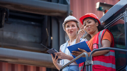 Female Foreman stay on lifting container cargo forklift check or inspect and control forklift concept service and transportation logistic.