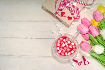 Heart shaped cup with red velvet hot chocolate, with small marshmallows, gift box and flowers for Valentine's day