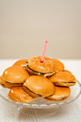 cheeseburger cake on a round platter. a candle into a hamburger