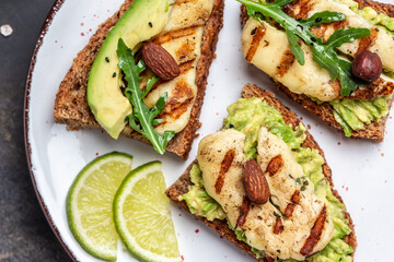 Bruschetta, toasted grilled Halloumi cheese and slices of avocado guacamole on white background top view with space for text. Healthy food
