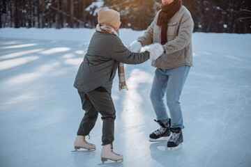 Fototapeta na wymiar Couple in love skating outdoors in the park in winter