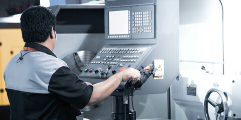Mechanical technician operate CNC lathe machine in workshop. Industrial manufacturing. © Itsanan