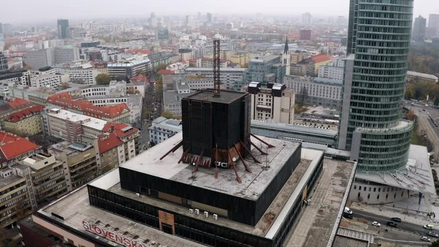 Dynamic Aerial shot of Slovak Radio inverted pyramid building in Bratislava on overcast day