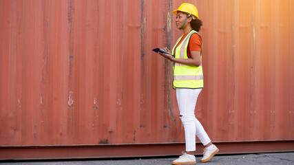 Woman foreman control loading Containers box in warehouse , Worker inspector or Safety Supervisor in Container CustomTerminal port concept import export transportation and logistic service