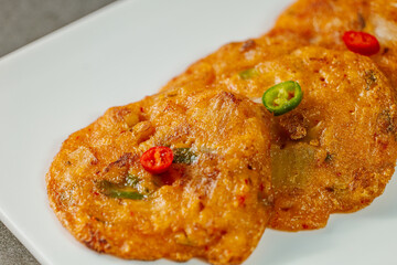 kimchijeon, Korean food kimchi pancake : Slices of well-fermented kimchi mixed into a flour batter and pan- fried. Finely chopped pork, squid, and clam meat may be added to the batter as well.