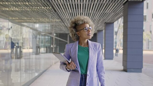 Confident black business woman walking in office district smiling empowered African American female executive enjoying successful corporate career