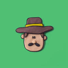 Farmer face with hat made of plasticine with isolated green background
