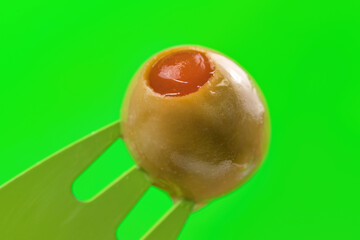 Macro of a stuffed olive in a green background