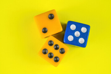 Yellow and blue dice over a solid color background