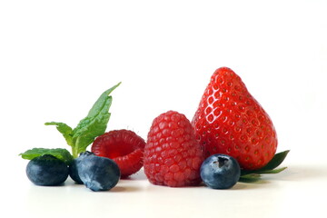 large juicy raspberries, strawberries, blueberries are photographed close-up. Isolated background