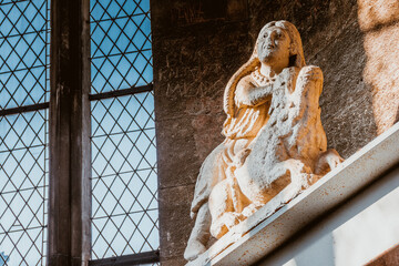 European church interior with stone sculpture by window 