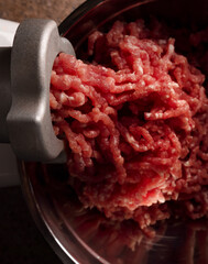 Process of preparing forcemeat by means of a meat grinder. Fresh red mincing close-up on black...