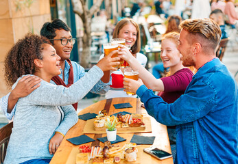 Diverse group of friends celebrating in outdoor pub