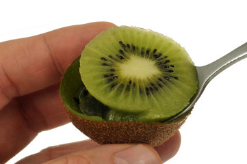 Manger un kiwi avec une petite cuillère en gros plan sur fond blanc