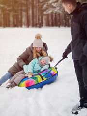 Have fun with your family in winter. Mom and daughter on the tube. Winter entertainment