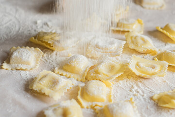 Fresh ravioli pasta is sprinkled with flour