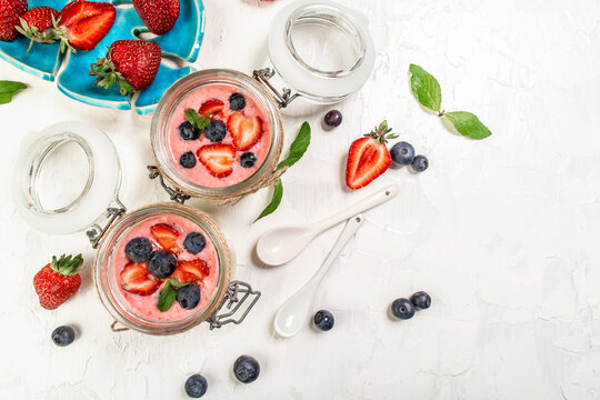 Traditional Italian dessert panna cotta with fresh berries. Summer yogurt dessert with mint leaves, vertical image, top view