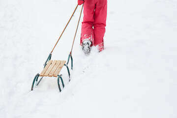 Fototapeta dziecko ciągnące sanki w zimie obraz
