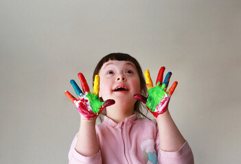 Cute little kid with painted hands. Isolated on grey background.