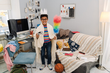 Black boy smiling while posing with joystick and colorful duster