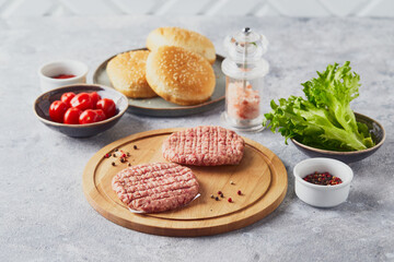 Raw veal mince Burger steak cutlets on wooden cutting board