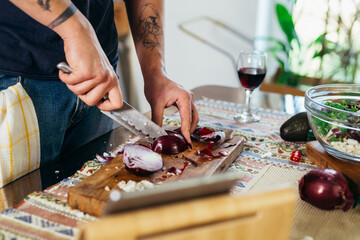 close up of man cutting red onion . cooking at home