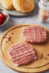 Raw veal mince Burger steak cutlets on wooden cutting board